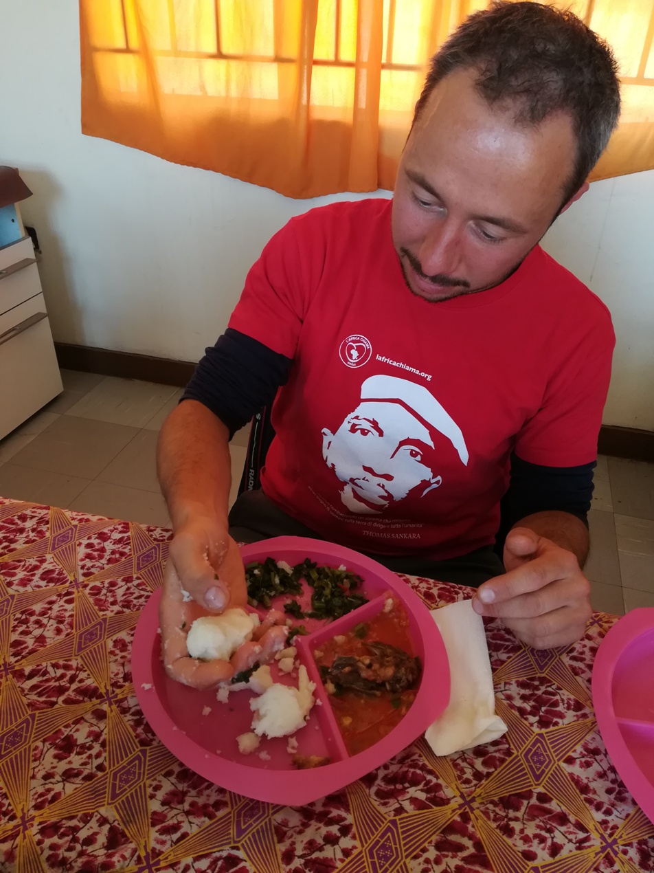 Mattia con un tipico pranzo zambiano composto da nshima, pollo e verdure rigorasamente mangiato con le mani