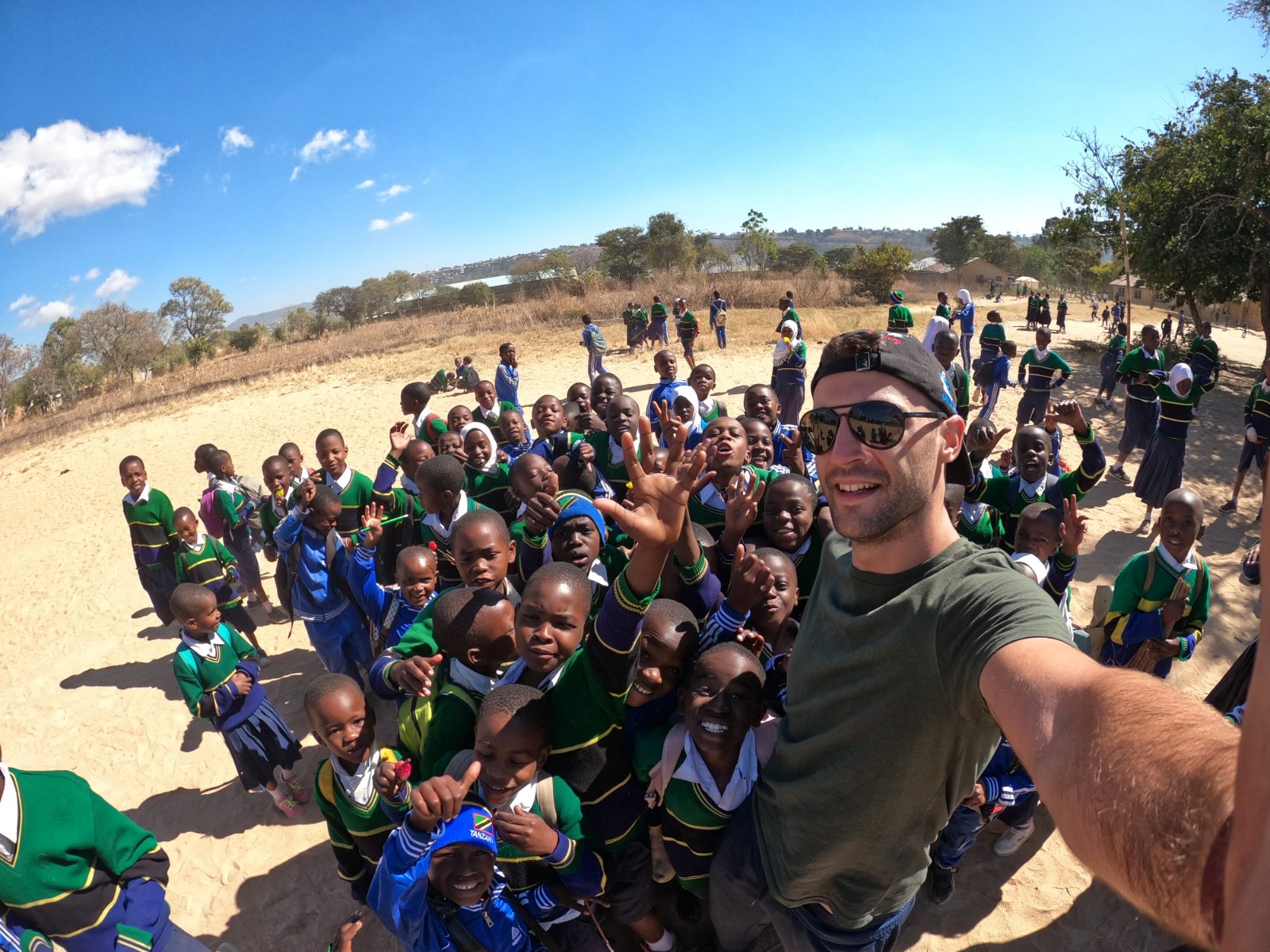 foto di Fabrizio con le bambine ed i bambini delle Mensce scolastiche in Tanzania